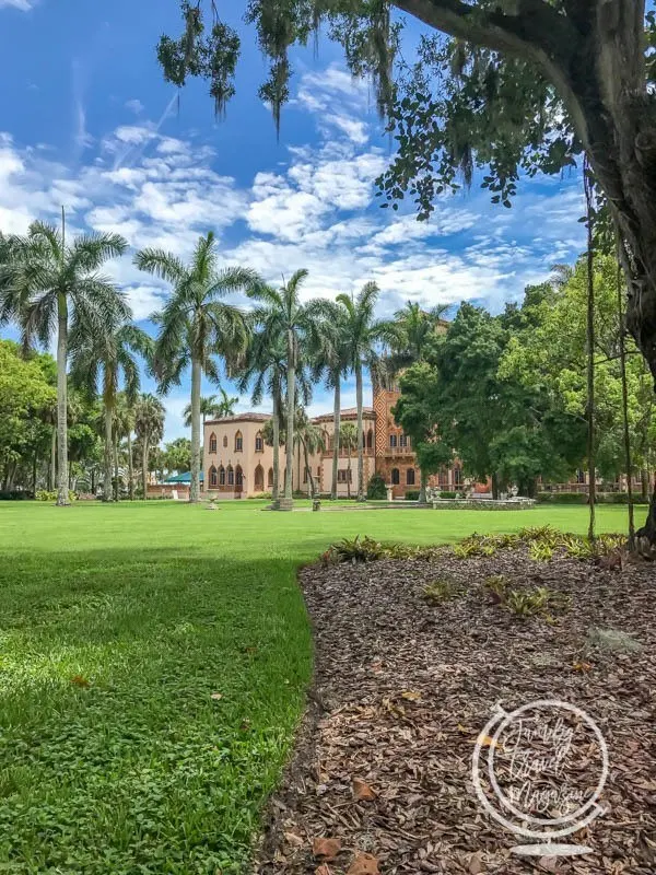 Mansion with palm trees in front of it 