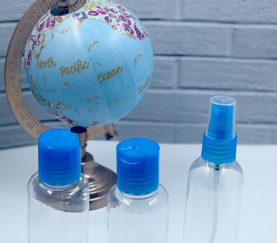 Toiletry refillable bottles in front of globe