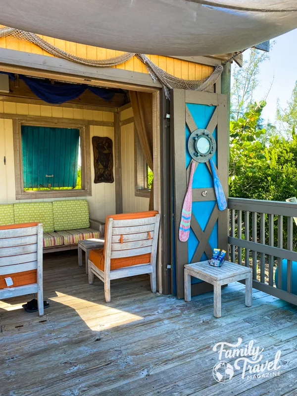 Castaway Cay cabana with patio, table, chairs, and couch. 