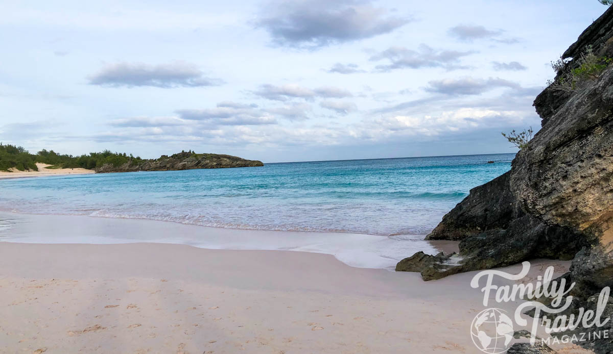 Horseshoe beach in Bermuda with light pink/tan sand and blue water