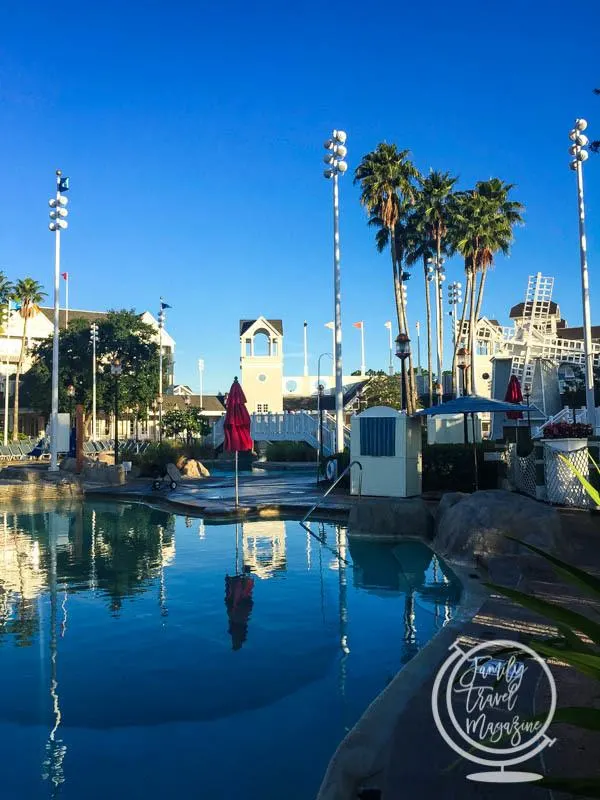 Disney's Stormalong Bay at the Yacht and Beach Clubs with pool, palm trees, model windmill, and red lifeguard umbrella