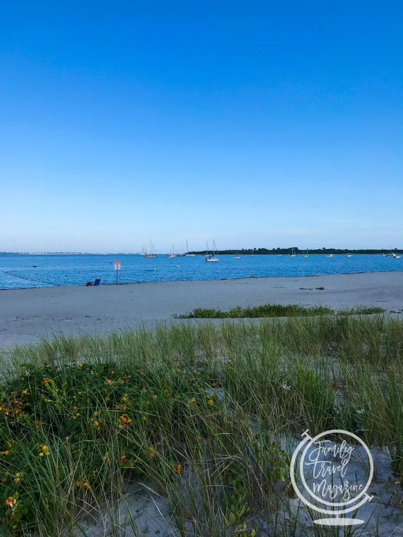 Quiet beach in Newport with sailboats in the background 