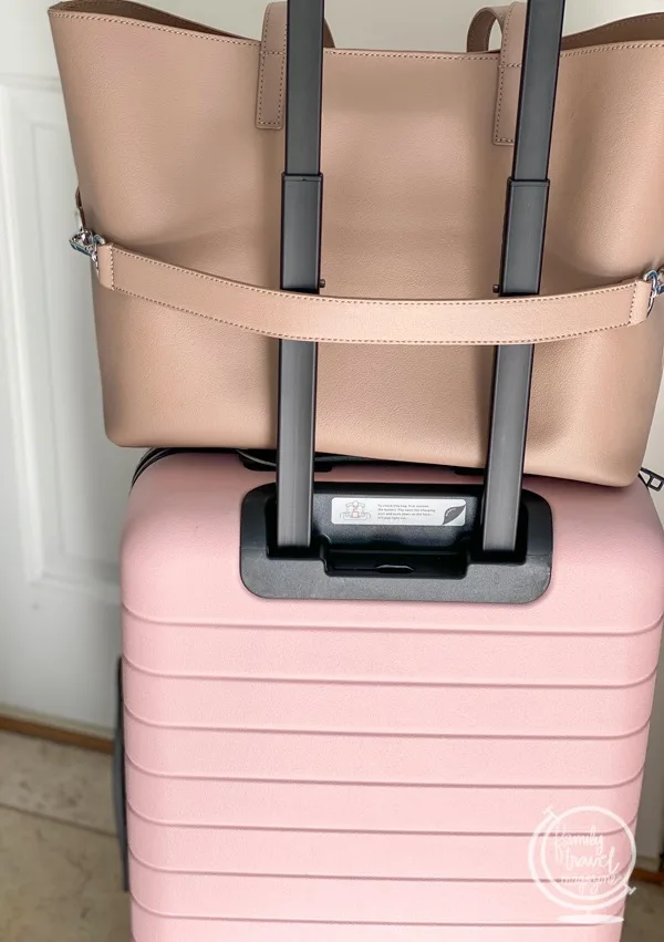 Tote on top of pink roller bag