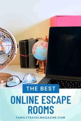 Fan, glasses, globe, and notebooks on a desk with a laptop computer.