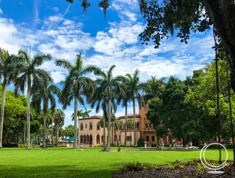 Mansion with palm trees in front of it