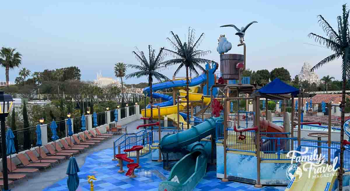 Overview of water park with slides, pool, and palm trees