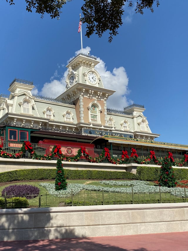 The Magic Kingdom's railroad station decorated for Christmas with wreaths and red bows