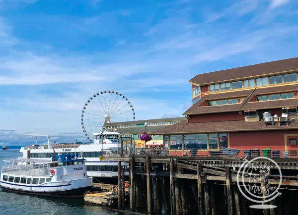 Tour boat at dock with ferris wheel in the background