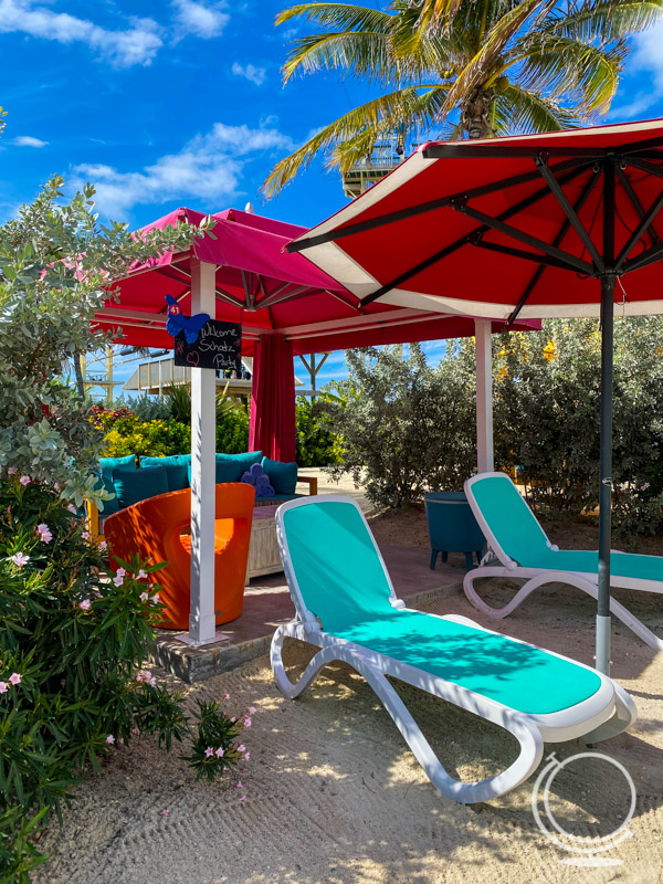 Waterpark cabana with lounge chairs and umbrella