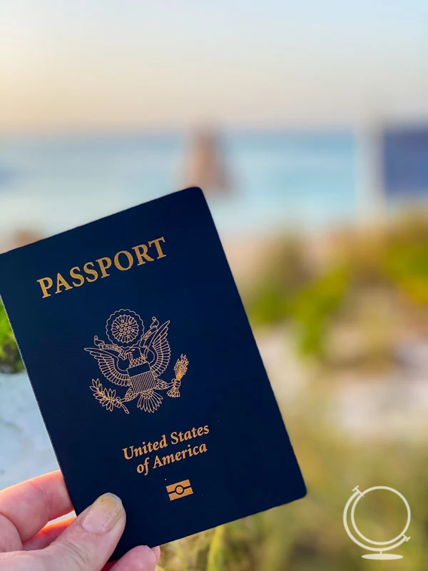 Passport in hand in front of beach