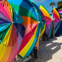 Colorful huge umbrellas on their sides lined up along the beach