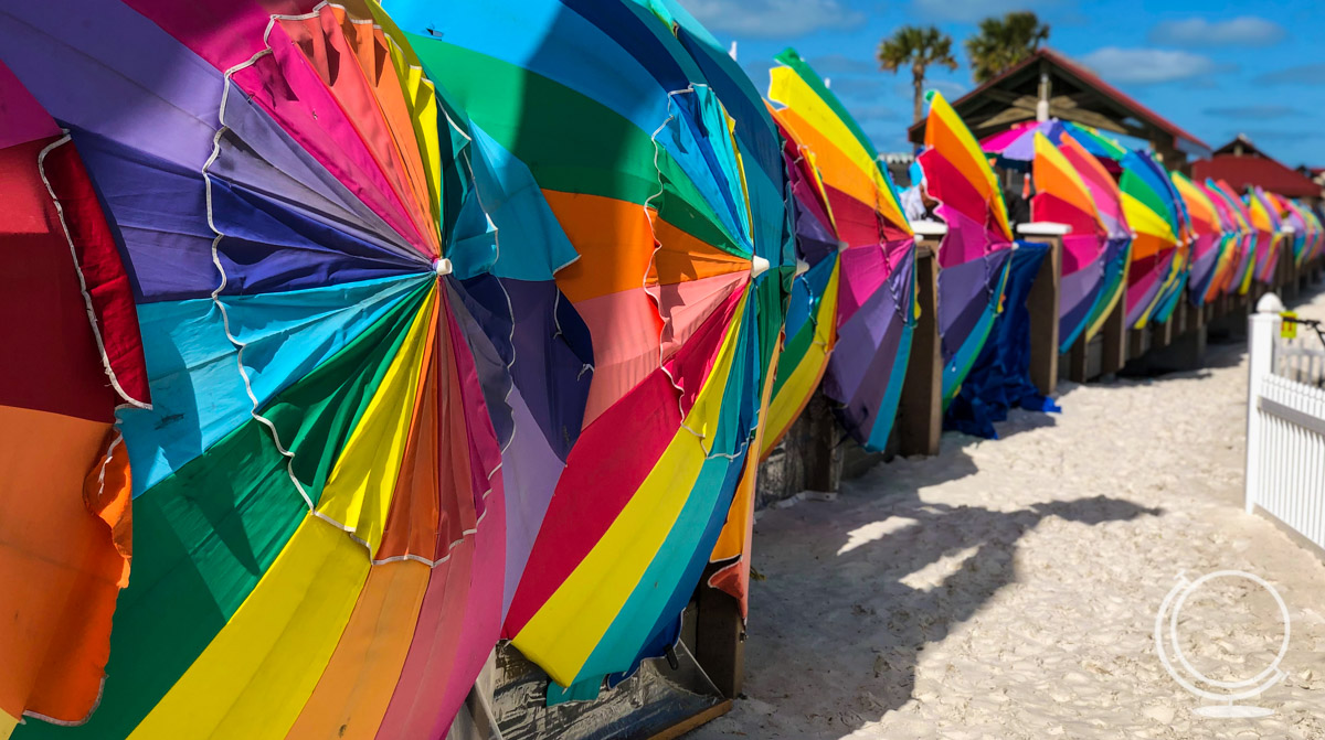 Colorful huge umbrellas on their sides lined up along the beach
