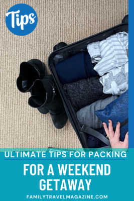 Hands in suitcase with rolled clothes in it with boots on the side