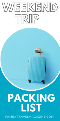 Photo of baby blue suitcase with a hat on the handle, against a blue wall - weekend trip packing list