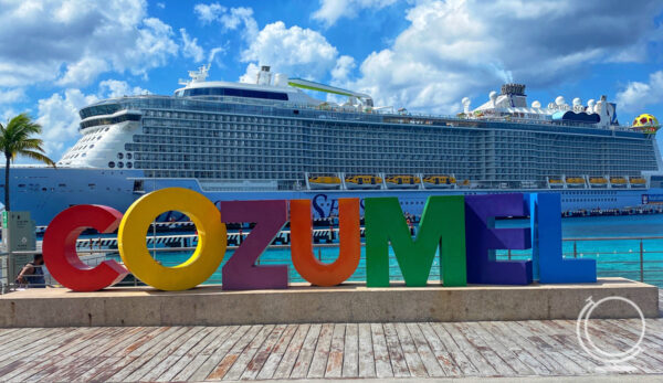 Large colorful letters spelling out Cozumel in front of the Odyssey of the Seas cruise ship. 