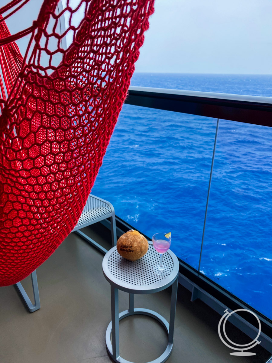 Red hammock on balcony with coconut on table 
