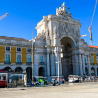 Rua Augusta Arch with yellow building and white arch.