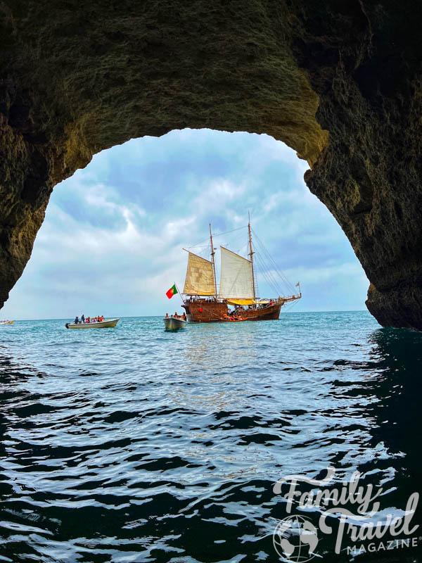 Pirate ship in open water as seen through a cave opening