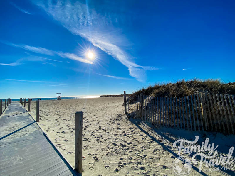 wooden path with wooden fence and sand leading to the beach