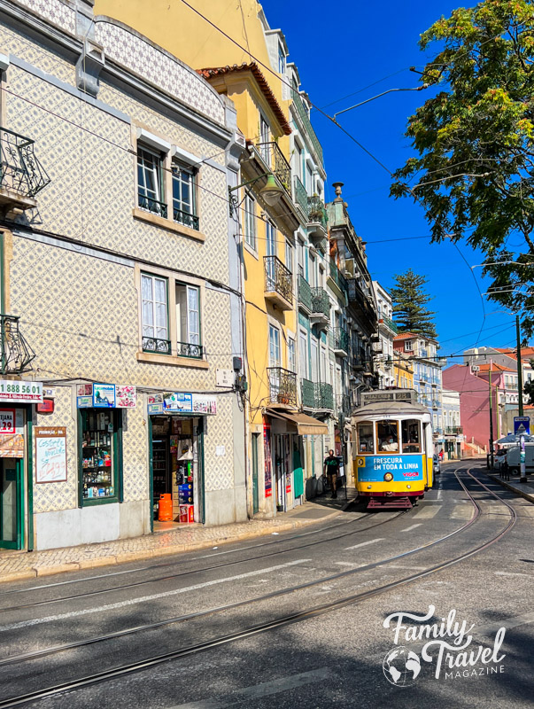 Tram on tracks next to colorful buildings