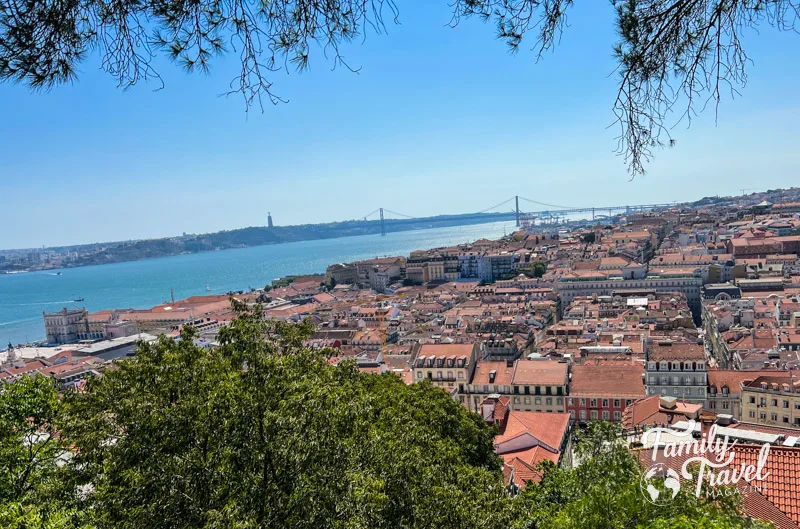 View from Castelo de S. Jorge with orange rooftops on building with water and bridge