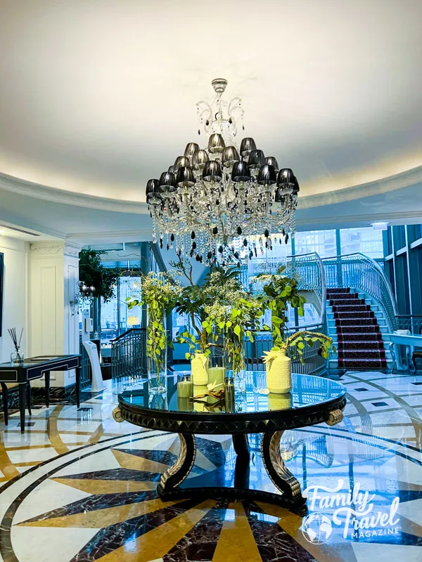 Lobby with chandelier, staircase, table, flowers