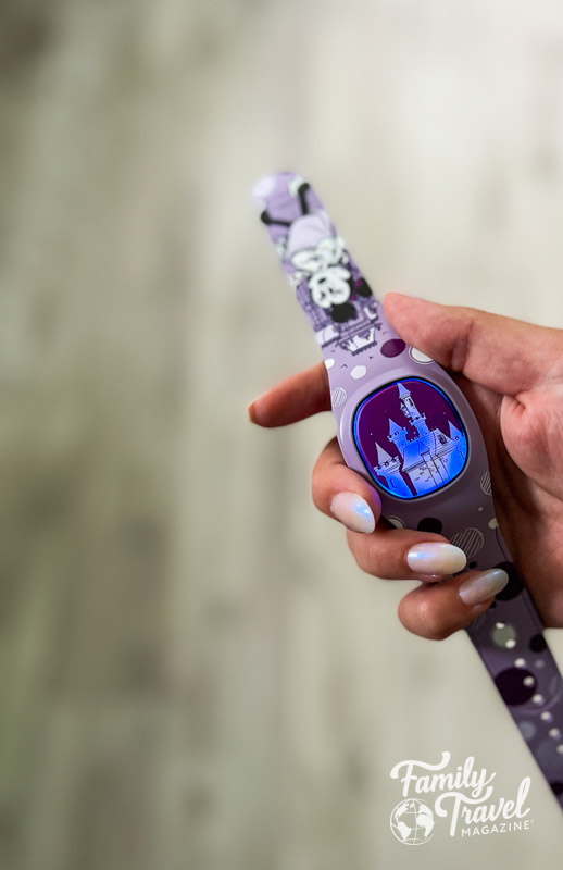 Purple MagicBand+ with castle on face and Minnie on band held in hand