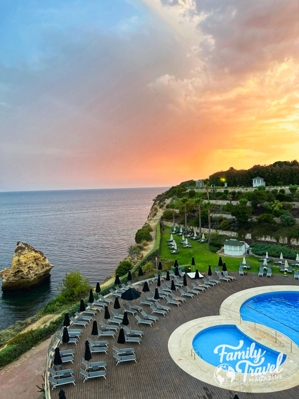 Sunset over cliffs and ocean with outdoor pool in the foreground