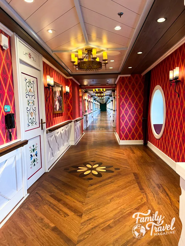 Long hallway with red wallpaper, decorative wooden floor