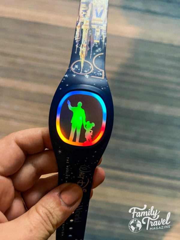 50th anniversary MagicBand with partner statue silhouette face lit up in rainbow colors. 