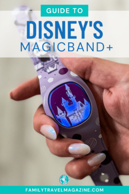 Hand holding purple MagicBand+ with lit up castle. 