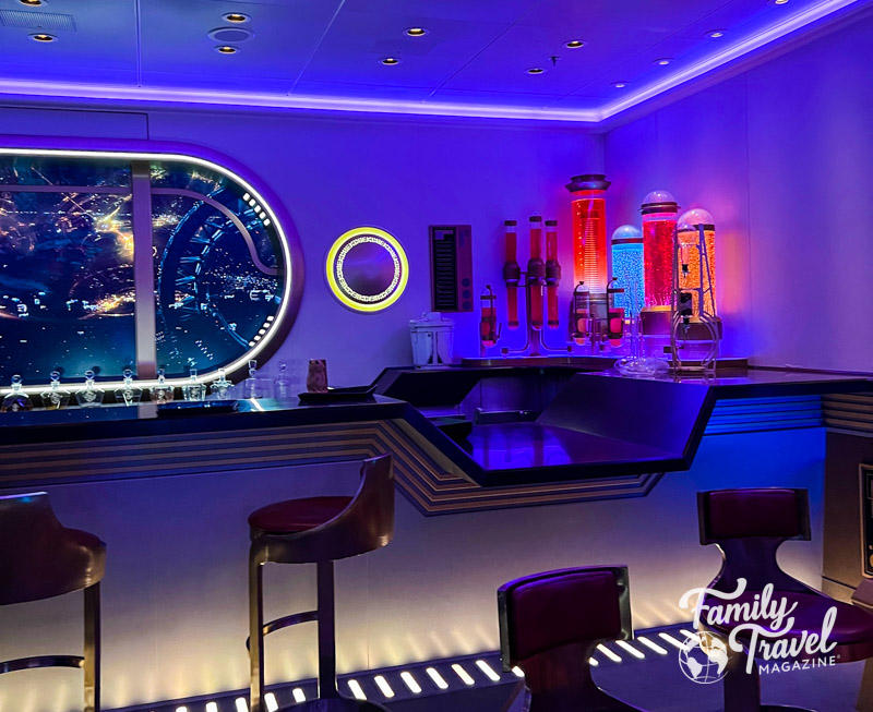 Bar at Star Wars Hyperspace Lounge with Star Wars scene on window and bubbling liquids in glass containers. 