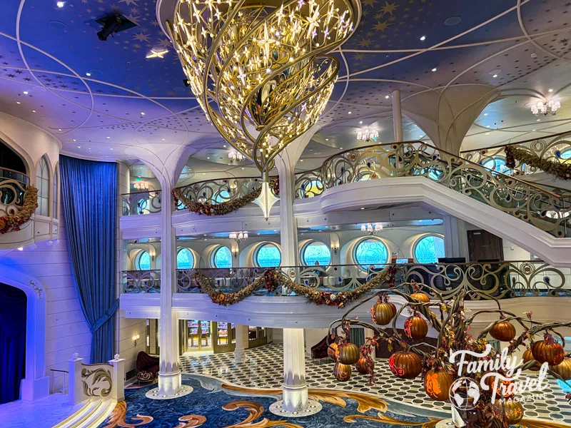 Three level atrium on the Disney Wish with chandelier and pumpkin tree