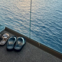 Four pairs of shoes on a balcony overlooking water