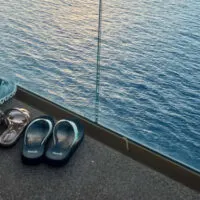 Four pairs of shoes on a balcony overlooking water