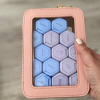 Carry on case with pink trim and purple and blue bottles