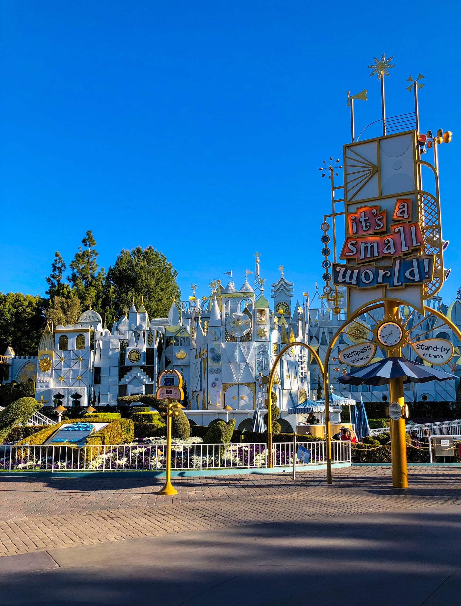 Exterior of it's a small world with white buildings and pastel sign