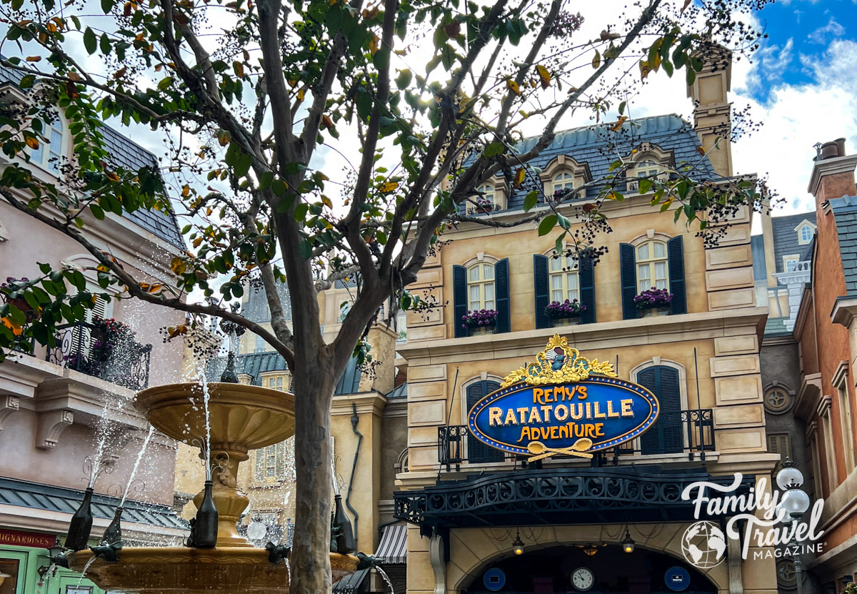 The outside of Remy's Ratatouille Adventure with a tree and fountain in the foreground