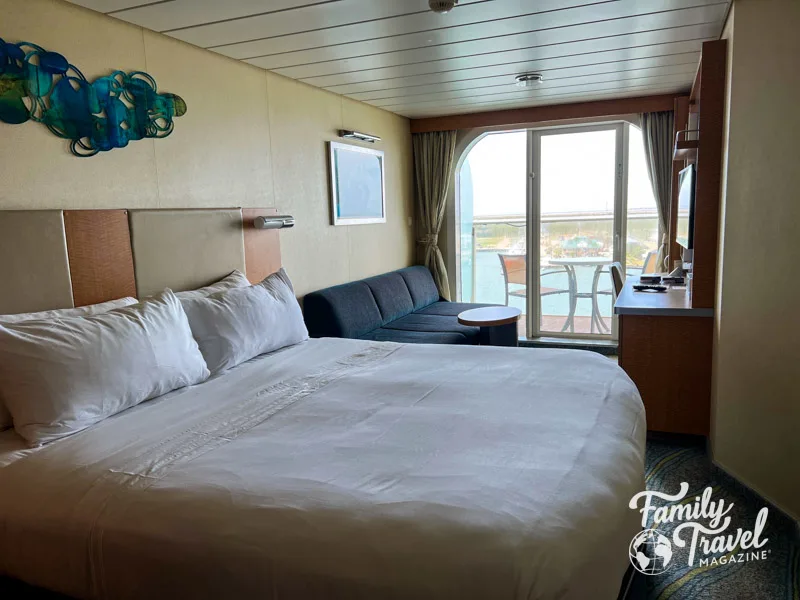 Stateroom on Allure of the Seas with bed, couch, desk, and balcony 