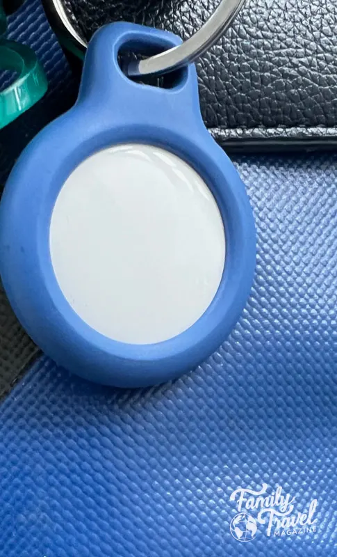 Back of Airtag in blue holder on blue suitcase