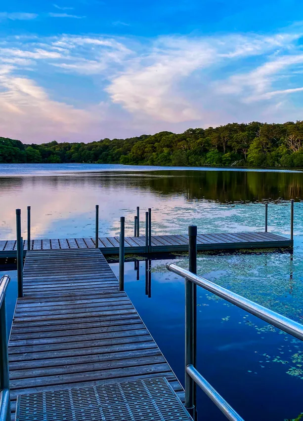 Pond at sunset with wooden dock in front