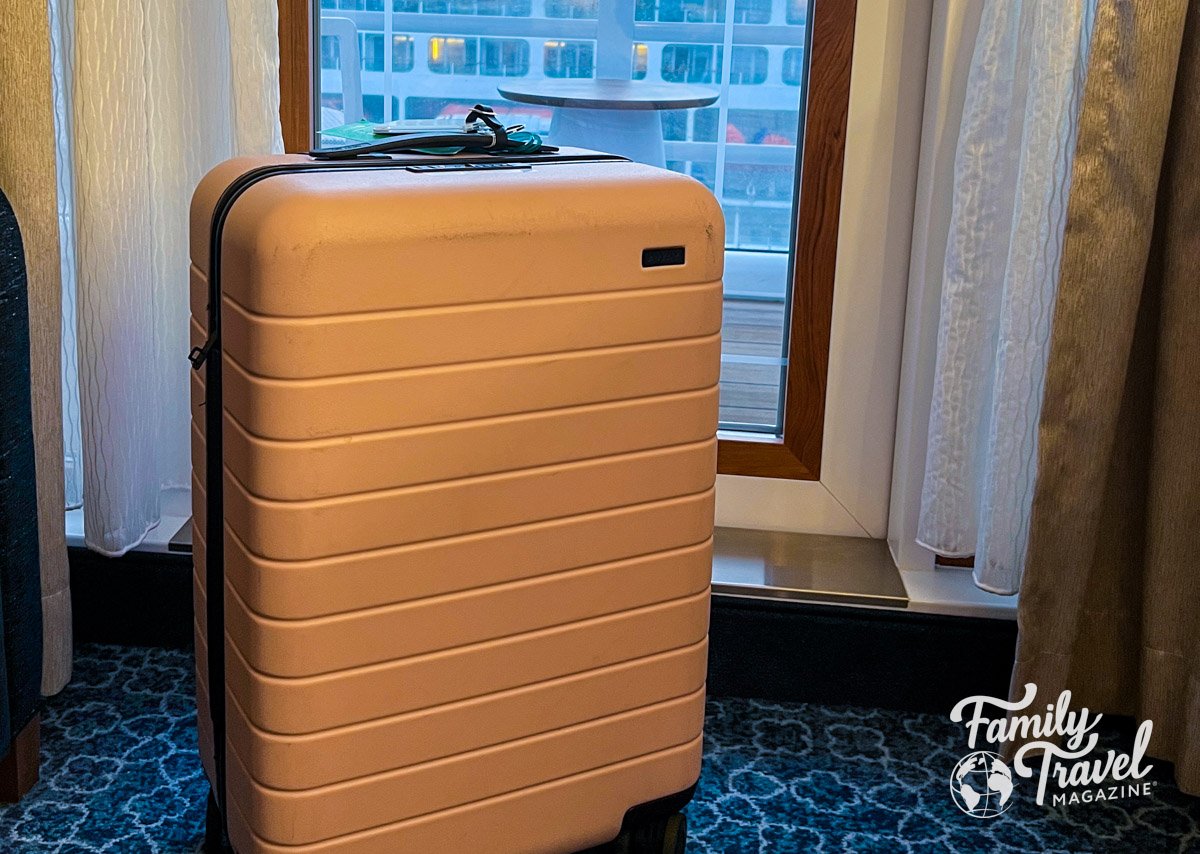 Pink suitcase in front of cruise balcony