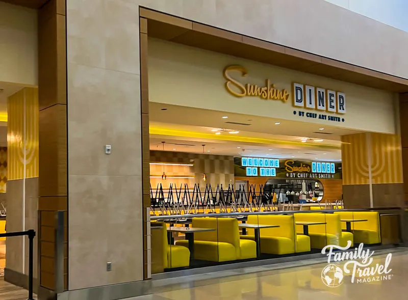 Exterior of closed Sunshine Diner with yellow benches and signs