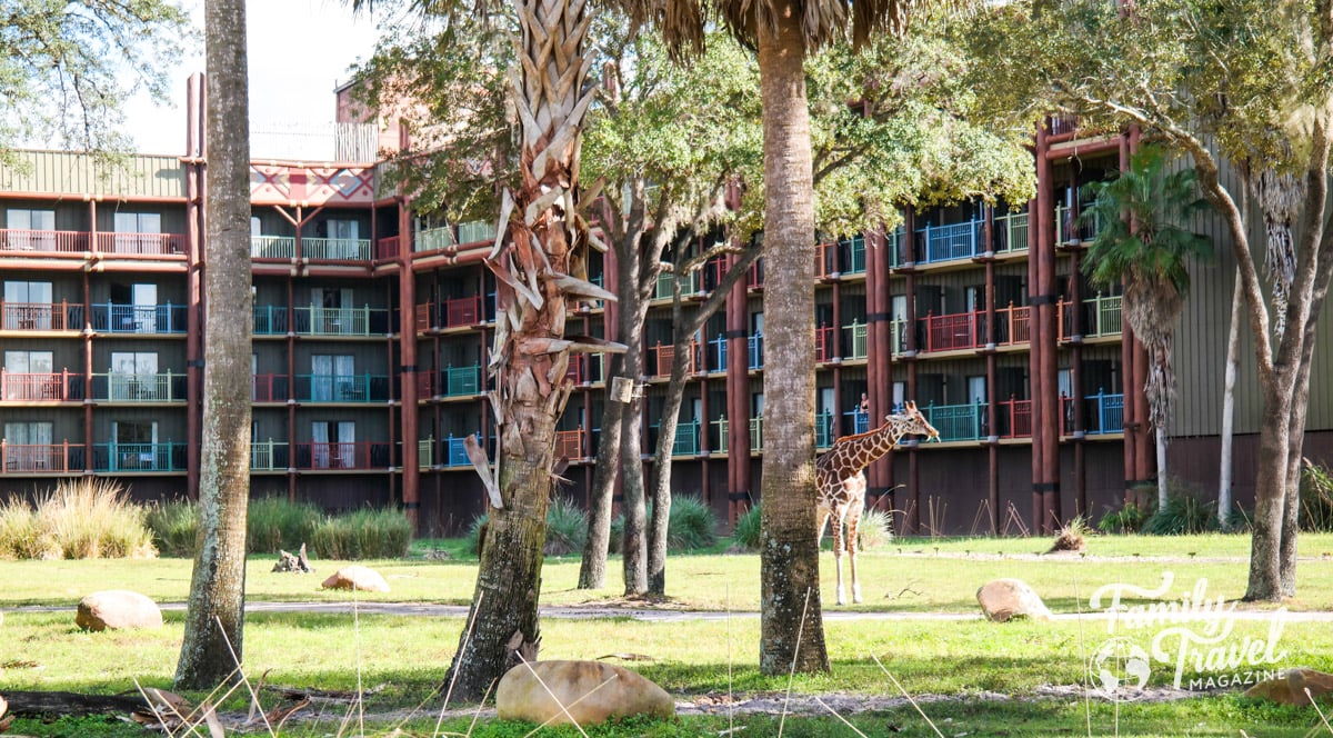 Exterior of Disney's Animal Kingdom Lodge with trees and a giraffe 