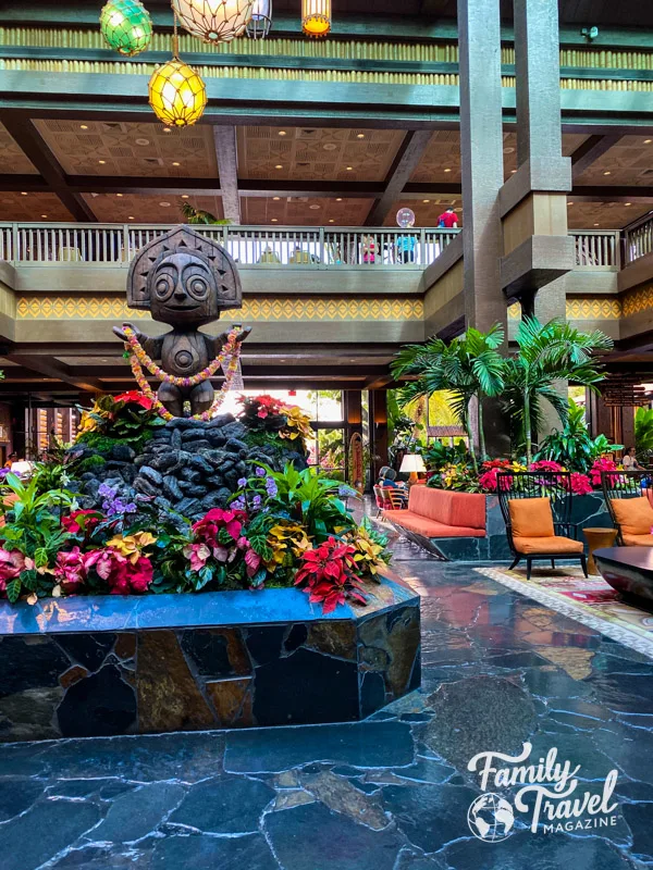 Tiki statue in center of lobby with flowers and seating