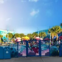 The Deep Blue Pool from the other side of the fence with colorful Nemo decor and palm trees - (the best Disney World hotel for toddlers)