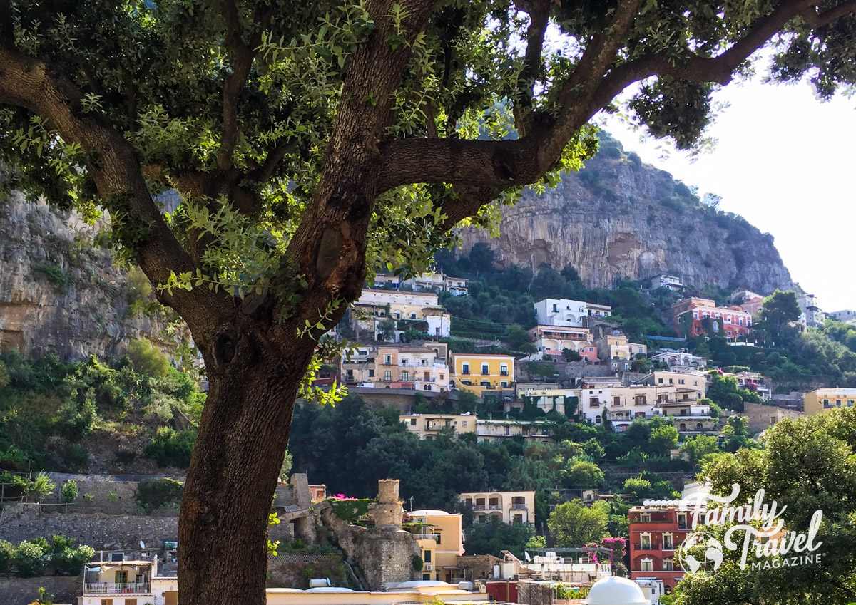 Buildings against cliff with tree in foreground - Amalfi Coast with kids 