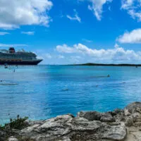 Disney Wish docked at Castaway Cay with small beach in the foreground