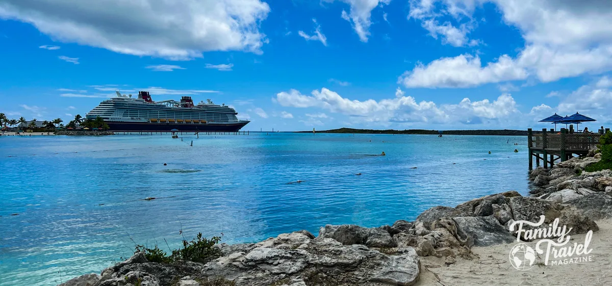 Disney Wish docked at Castaway Cay with small beach in the foreground (Disney Wish staterooms post)