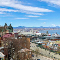 View of river with old buildings, Chateau Frontenac, and boardwalk